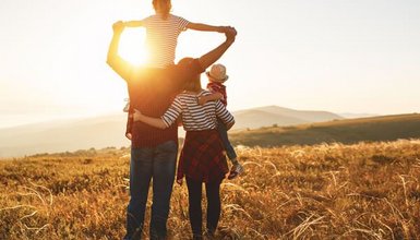 Familie schaut harmonisch in den Sonnenuntergang